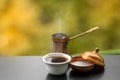 Hot tasty steaming coffee brewed in traditional turkish coffee pot