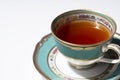 Hot tea in an antique cup and saucer on a white background Royalty Free Stock Photo