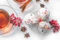 Hot tea on Christmas in glass transparent Cup with tea tree and cakes in the shape of snowmen out of meringue, cinnamon