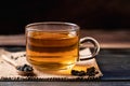 Hot tea in cup glass with dried tea leaves on wooden background Royalty Free Stock Photo