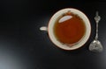Hot tea cup white porselain with spoon,at black wooden background / teatime Royalty Free Stock Photo