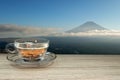 hot tea cup on a wooden table with fuji san mountain and city top view scenery Royalty Free Stock Photo