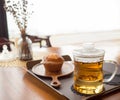 Hot tea in glass cup with bakery cake on table and white light background