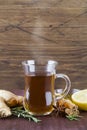 Hot tea in glass cup with honey cinnamon lemon rosemary and ginger on wood background Royalty Free Stock Photo