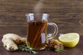 Hot tea in glass cup with honey cinnamon lemon rosemary and ginger on wood background Royalty Free Stock Photo