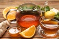 Hot tea, honey, ginger and citruses on wooden table