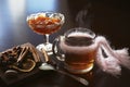 Hot tea with jam on a dark table. Seasonings cinnamon, cloves, dried lemon