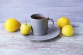 Hot tea in a large cup, lemons and apples on a wooden table, yellow and gray color Royalty Free Stock Photo