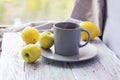 Hot tea in a large cup, lemons and apples on a wooden table, yellow and gray color Royalty Free Stock Photo