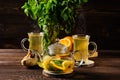 Hot tea with lemon, orange, ginger and mint on wooden table in the morning Royalty Free Stock Photo