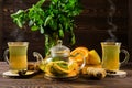 Hot tea with lemon, orange, ginger and mint on wooden table in the morning Royalty Free Stock Photo