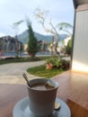 Hot tea with milk view swimming poll and mountain