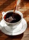 Hot tea is poured into a cup on a saucer Royalty Free Stock Photo