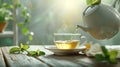 Hot tea is pouring from a teapot into cup with magical morning background Royalty Free Stock Photo