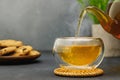 hot tea pouring from teapot into glass cup on table Royalty Free Stock Photo