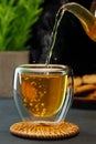 hot tea pouring from teapot into glass cup on table Royalty Free Stock Photo