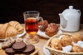 Hot tea put on table, drink breakfast in the morning day, breakfast with croissants and sweets on wooden table Royalty Free Stock Photo