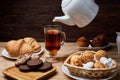 Hot tea put on table, drink breakfast in the morning day, breakfast with croissants and sweets on wooden table Royalty Free Stock Photo