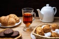 Hot tea put on table, drink breakfast in the morning day, breakfast with croissants and sweets on wooden table Royalty Free Stock Photo