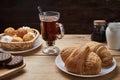 Hot tea put on table, drink breakfast in the morning day, breakfast with croissants and sweets on wooden table Royalty Free Stock Photo