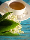 Hot tea in a white cup with a bouquet of flowers