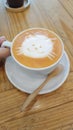 Hot Thai tea in a cup decorated with a cute cat is placed on the table. morning drink Royalty Free Stock Photo