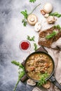 Hot thick mushroom soup with beef, spices and wholegrain barley, meat broth. With black bread, in metal pan, top view, flat lay,