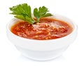 Hot tomato sauce with parsley leaves in a small white ceramic round bowl isolated on white background Royalty Free Stock Photo