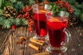 Hot traditional drink Mulled wine on the wooden brown background closeup. Christmas and New Year vignette of branches of blue fir Royalty Free Stock Photo