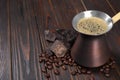 Hot turkish coffee pot, beans and chocolate on wooden table, space for text Royalty Free Stock Photo