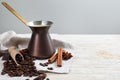 Hot turkish coffee pot, beans and spices on white wooden table, space for text Royalty Free Stock Photo