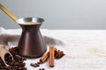 Hot turkish coffee pot, beans and spices on white wooden table, space for text Royalty Free Stock Photo