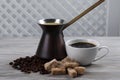 Hot turkish coffee pot, beans and sugar on white wooden table Royalty Free Stock Photo