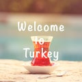 Hot turkish tea outdoors near water. Turkish tea and traditional turkish culture concept. Welcome to Turkey text