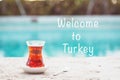 Hot turkish tea outdoors near water. Turkish tea and traditional turkish culture concept. Welcome to Turkey text Royalty Free Stock Photo
