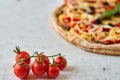 Hot vegetarian pizza with tomatoes, bell pepper, onion, black olives, cheese and spices on blurred white background close up Royalty Free Stock Photo