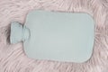 Hot water bottle on a fur, freezing winter, keep warm, high energy costs Royalty Free Stock Photo