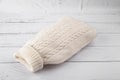 Hot water bottle in a white knitted cover