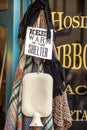 Hot water bottle, woolen gloves, and blanket hanging outside drapers shop