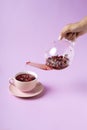 Hot water poured from the teapot into a cup with dried Fall flowers