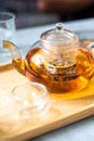 Hot water with tea leaves in teapot and cup on the table .Process brewing tea,tea ceremony,Cup of freshly brewed