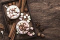 Hot winter or autumn drink with cocoa, chocolate, spices and marshmallows in cups on vintage wooden background top view Royalty Free Stock Photo