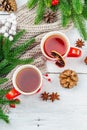 Hot winter or Christmas tea in ceramic red cups. Fir tree branches, lemon slice, spices and berries Royalty Free Stock Photo