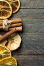 Hot winter holiday beverage aroma ingredients. Dried orange apple slices cinnamon sticks on old plank wood. New year Christmas