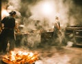 A hot wok with chef in a Chinese kitchen. back view of the chef, Chinese food being cooked in a wok on fire in the Chinese kitchen Royalty Free Stock Photo