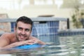 Hot young man floating on a mattress in water pool Royalty Free Stock Photo