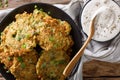 Hot zucchini fritters and sour cream sauce close-up on the table Royalty Free Stock Photo