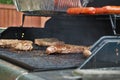Hotdogs and steak on the grill at a backyard cookout Royalty Free Stock Photo