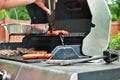 Hotdogs and steak on the grill at a backyard cookout