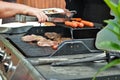 Hotdogs and steak on the grill at a backyard cookout